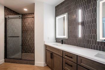 Spacious glass-enclosed, newly tiled showers with rainfall shower head*